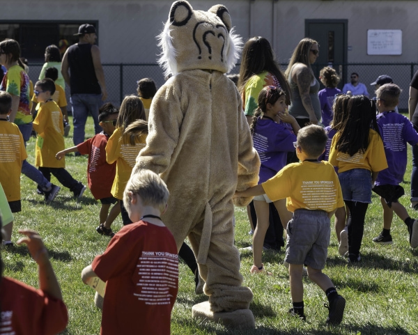 kids walking alongside a tiger mascot