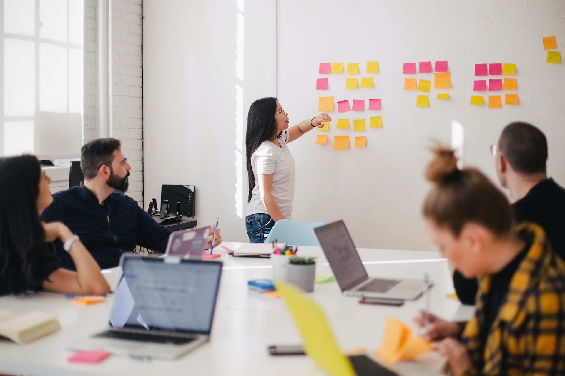 woman discussing with sticky notes on board