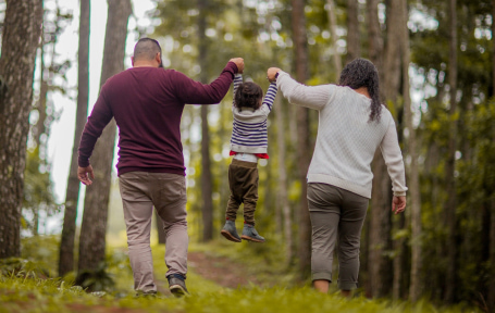 mom and dad lifting their kid with hands